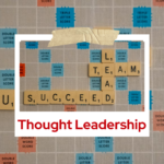 Graphic styled like a Scrabble board with letter tiles spelling ‘LEAD,’ ‘TEAM,’ and ‘SUCCEED.’ The design is framed like a taped Polaroid photo, with bold red text at the bottom reading ‘Thought Leadership.
